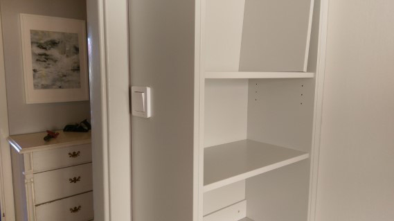 platsbyggd grå bokhylla med bänkskåp med inbyggd brytare för belysning